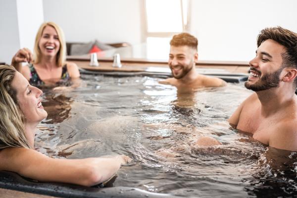 two men and two women in a hot tub