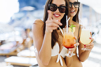 Beautiful women on beach enjoying cocktails
